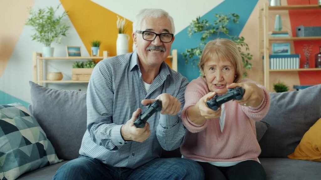 Portrait of senior husband and wife playing videogame then doing high-five enjoying leisure time activity and modern technology. Relationship and fun concept.