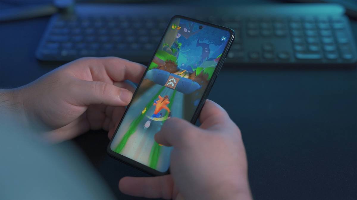 Young man playing Crash Bandicoot on the Poco X3 Pro